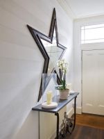 Modern star shaped mirror in classic hallway 