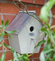 Detail of wooden bird box on brick wall 