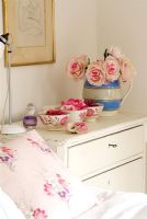 Flowers on chest of drawers in classic bedroom