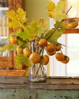Vase of leaves and sharon fruit