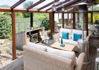 Decked patio with sofas and fireplace