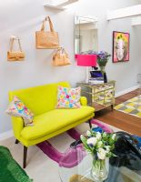 Open plan living room with designer handbags displayed on wall mounted hands
 