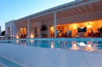 Greek villa with swimming pool lit up at night