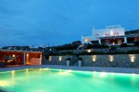 Greek villa and swimming pool lit up at night