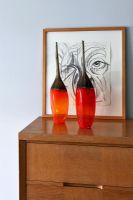 Red vases on wooden cabinet