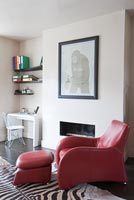 Red armchair by fireplace