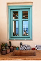 Turquoise window above stone sink
