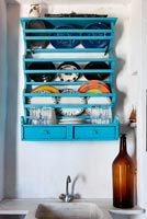Turquoise plate rack above marble sink