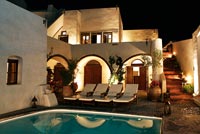 Villa with swimming pool lit up at night
