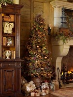 Christmas tree by stone fireplace
