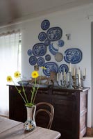 Collection of plates mounted above wooden dresser