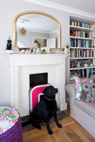 Black Labrador sitting by fireplace