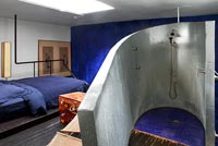 Industrial style open plan bedroom with en suite shower