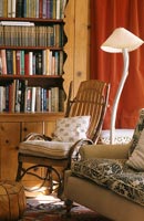 Cane armchair by bookshelves