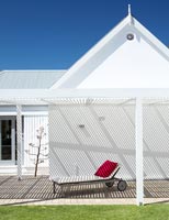 White house with lounger under pergola