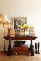 Wooden console table with piles of books