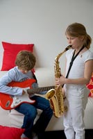 Girl playing saxophone and boy playing guitar