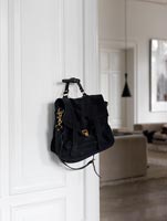 Black satchel hanging on door