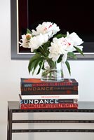 Flowers on top of pile of books 
