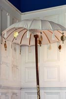 Decorative parasol in front of panelled wall