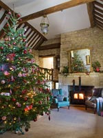 Galleried hall with cotswold stone fireplace at Christmas