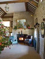 Galleried hall with cotswold stone fireplace at Christmas
