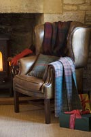 Leather armchair by cotswold stone fireplace at Christmas
