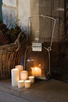 Cotswold stone fireplace with metal lantern and candles