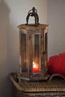 Wooden and glass storm lantern with red candle
