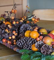 Christmas arrangement of Fir cones, fruit and berries on wooden table