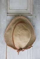 Vintage hat hanging from shutter