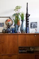 Retro sideboard with display of flowers and pottery