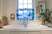 Display of blue glassware above bath