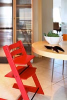 Round kitchen table and red high chair
