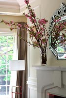 Blossom in vase on marble mantelpiece
 
