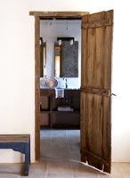 View of bathroom through wooden door