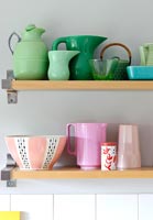 Colourful crockery on kitchen shelves