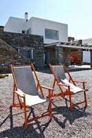 Modern deck chairs on gravel patio