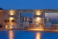 Stone wall with windows lit up at night