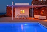Greek villa and pool lit up at night