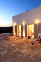 Traditional Greek villa lit up at dusk