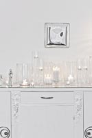 Candles and tea lights on white cabinet