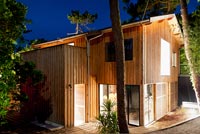 Contemporary wooden house lit up at night