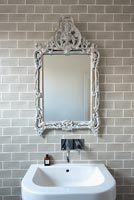 Ornate mirror above modern bathroom sink
