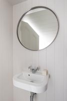 Round mirror above compact sink