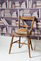 Wooden chair and patterned wallpaper
