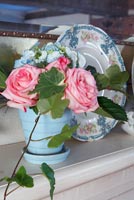 Pink Roses and Ivy foliage in blue pot