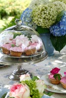 Garden table with cupcakes and Hydrangeas in vase