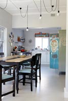 Modern kitchen diner with artwork on cupboard by Conrad Botes