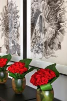 Arrangements of red Roses and tropical foliage